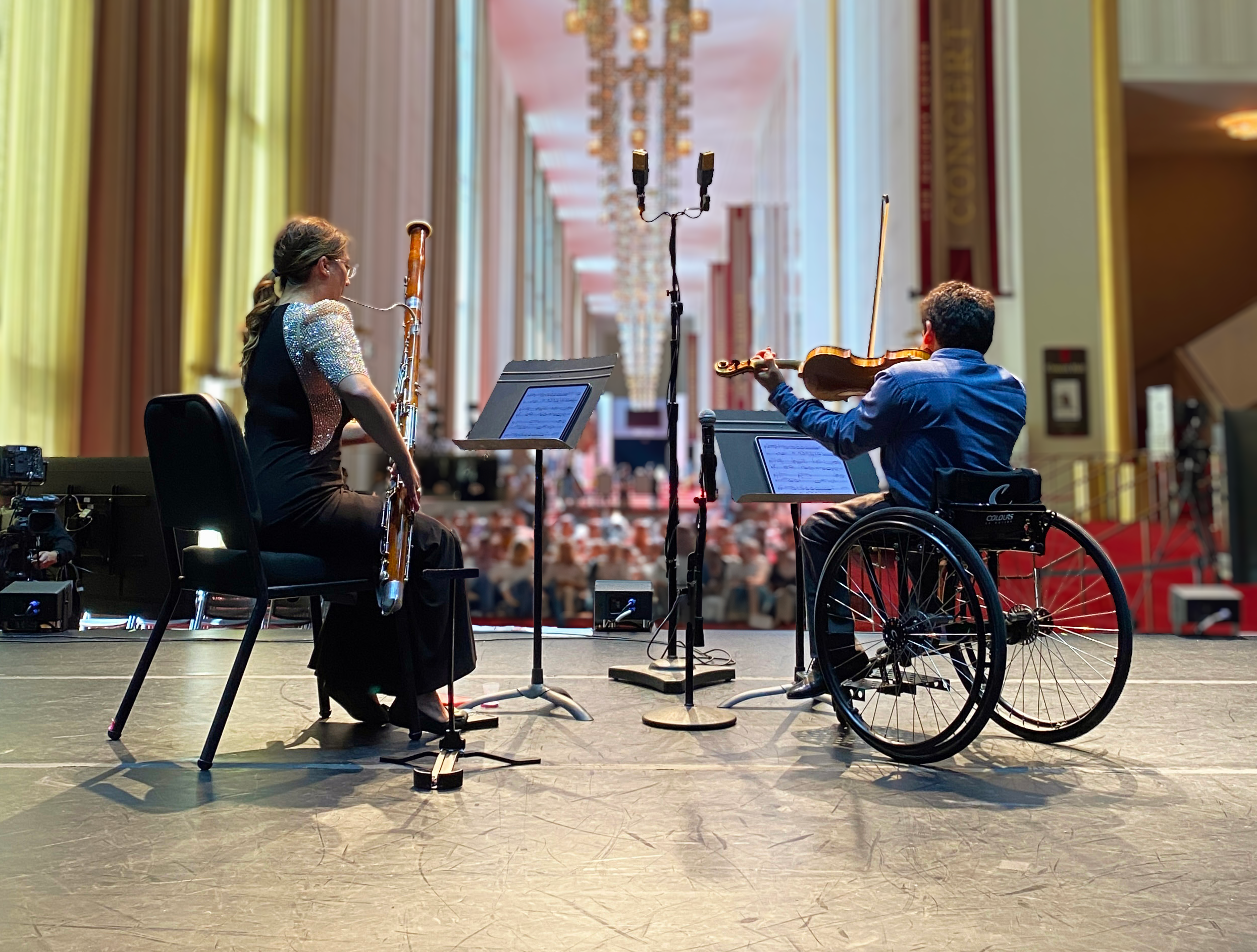 A person playing a bassoon and a person playing a violin
